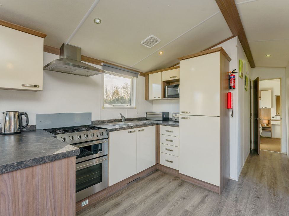 A kitchen with appliances and cabinets at Spruce Waterside Spa Carlton Miniott near Thirsk