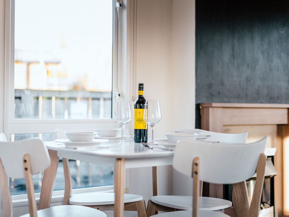 A dining room with a table set and a wine bottle at Spruce Waterside Spa Carlton Miniott near Thirsk