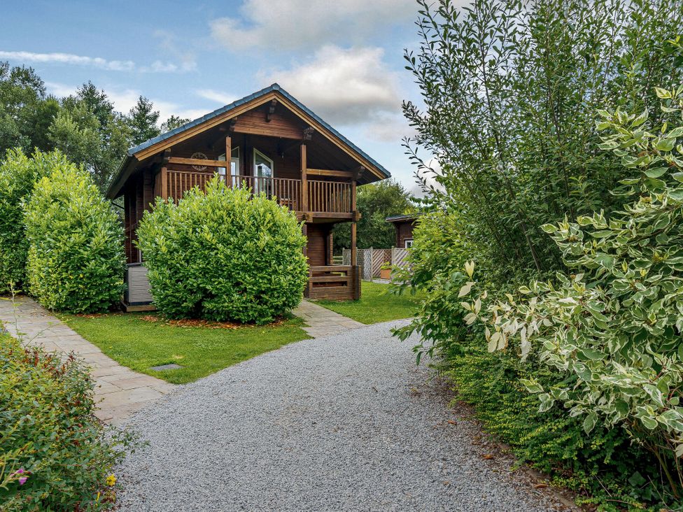 A cabin with a pathway and bushes at Birch Spa Carlton Miniott near Thirsk