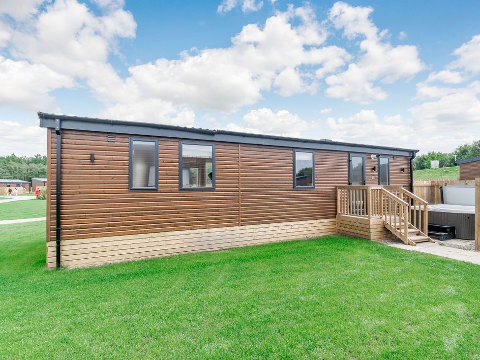 A modular home with a wooden deck outside at Cedar Spa Carlton Miniott near Thirsk