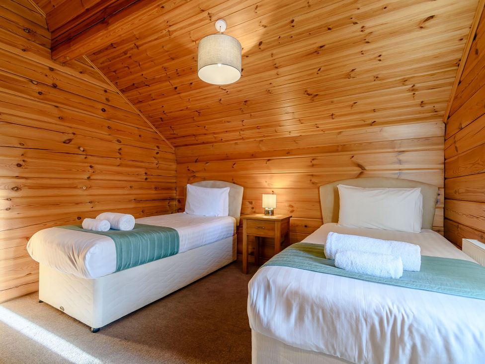 A bedroom with two single beds and a bedside table at Birch Waterside Spa (Pet) Carlton Miniott near Thirsk