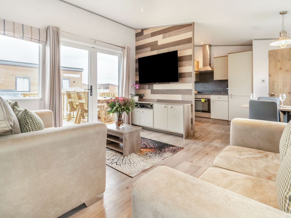 A living room with a sofa, coffee table, and television at Kinder Spa in Carlton Miniott near Thirsk