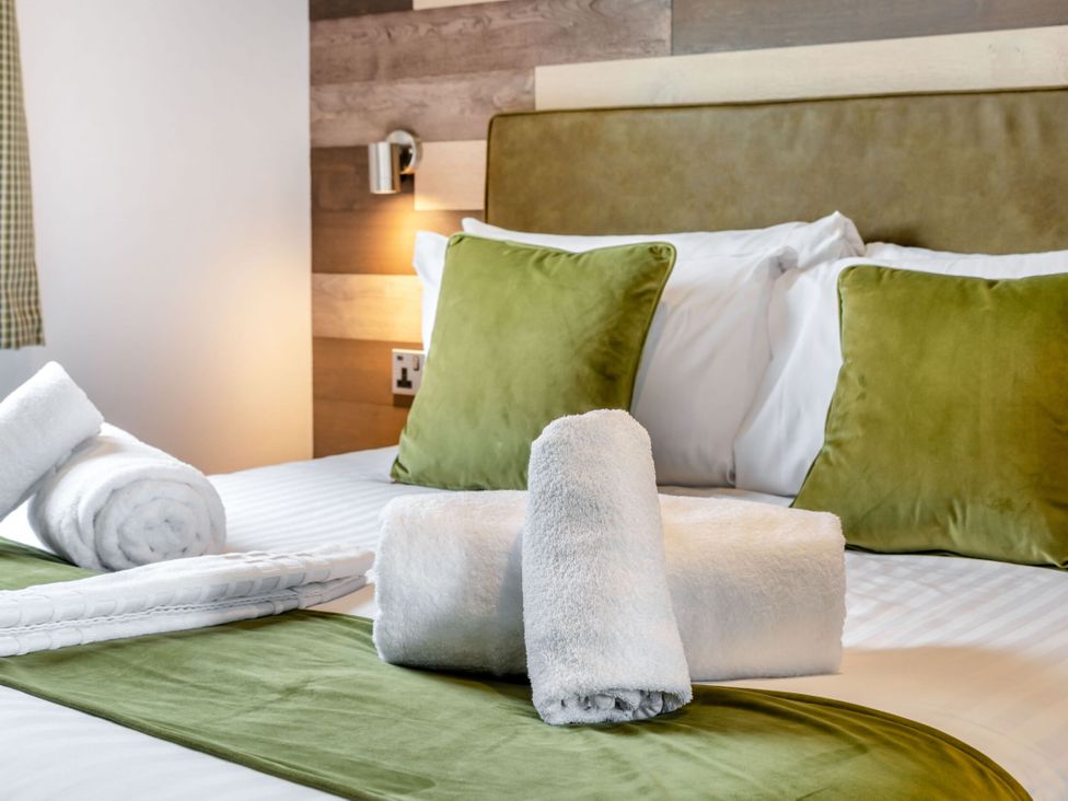 A bedroom with bed, pillows, and towels at Kinder Spa in Carlton Miniott near Thirsk
