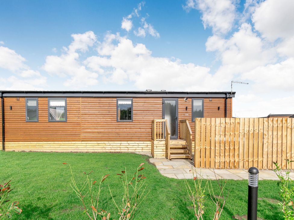 A wooden building with steps and a fence at Kinder Spa (Pet) Carlton Miniott near Thirsk