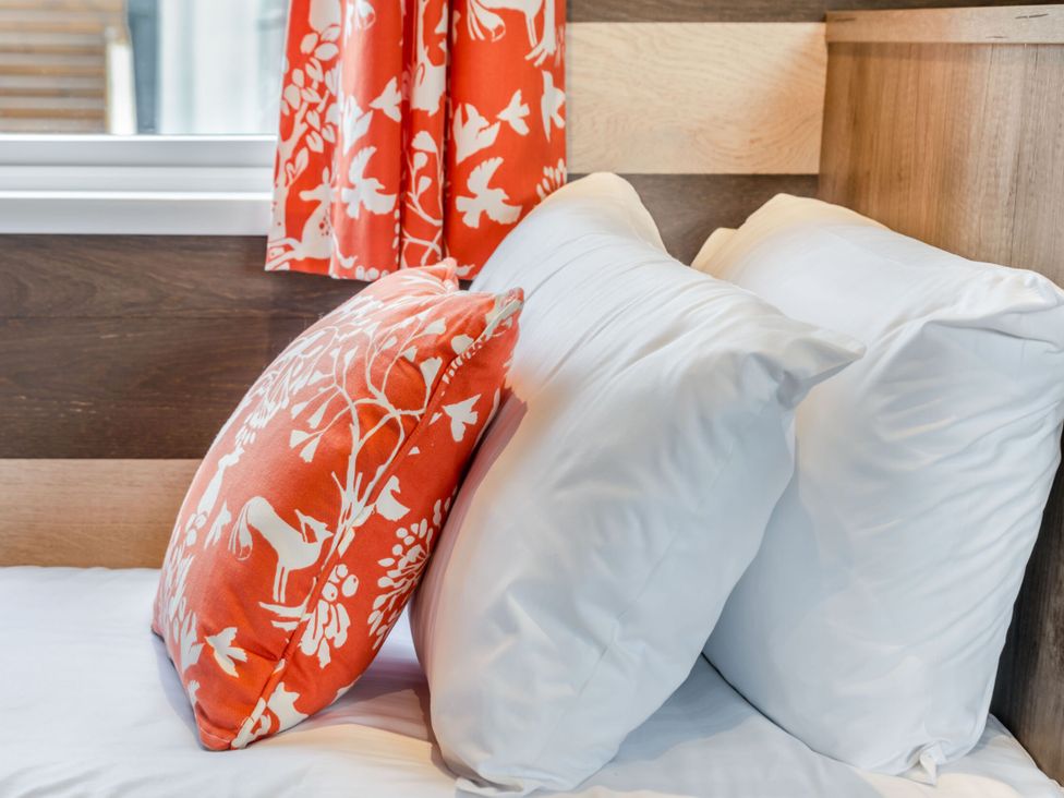 Pillows on a bed with a curtain at Kinder Spa (Pet) Carlton Miniott near Thirsk