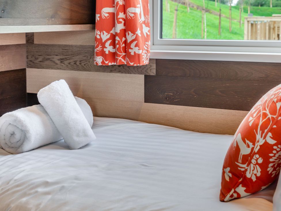 A bedroom with a bed and towels at Kinder Spa (Pet) Carlton Miniott near Thirsk