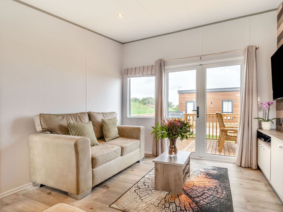 A living room with seating and glass doors at Kinder Spa (Pet) Carlton Miniott near Thirsk