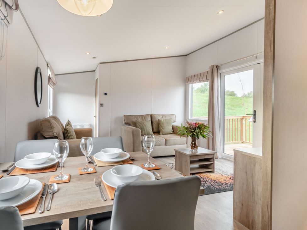 A living room with a dining table and sofa at Kinder Spa (Pet) Carlton Miniott near Thirsk