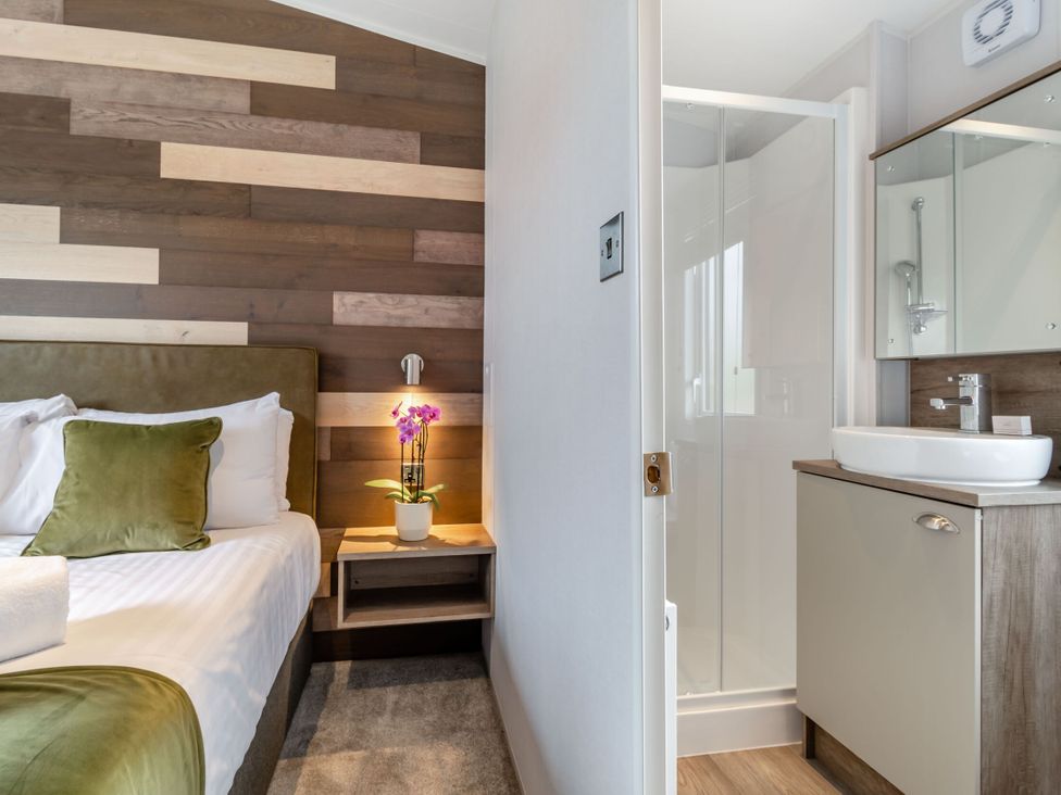 A bedroom with a bed and an attached bathroom at Kinder Spa (Pet) Carlton Miniott near Thirsk