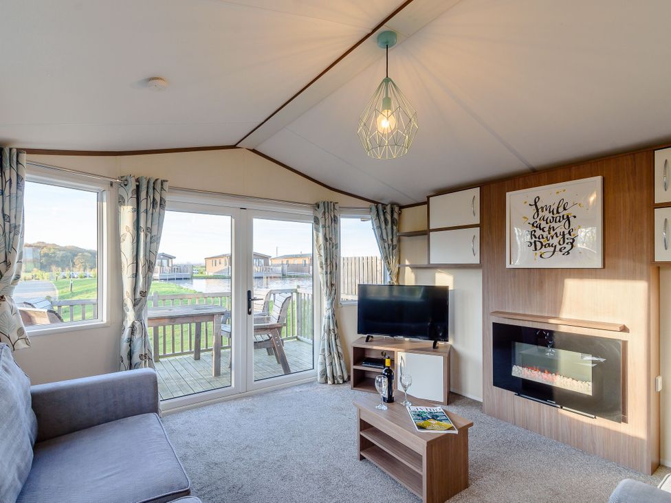 A living room with a sofa and television at Alder Spa (Pet) Carlton Miniott near Thirsk