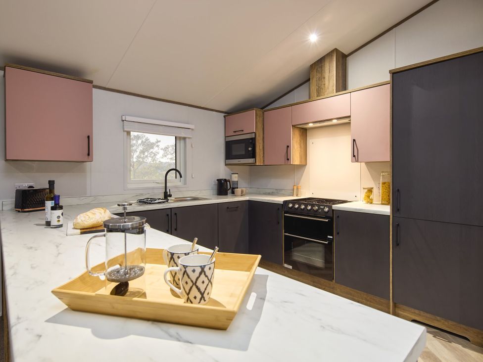 A kitchen with countertop, stove, cabinets and utensils at Laurel Spa Carlton Miniott near Thirsk