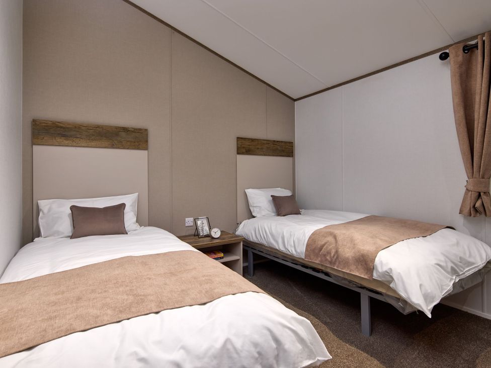 A bedroom with twin beds and a bedside table at Laurel Spa Carlton Miniott near Thirsk