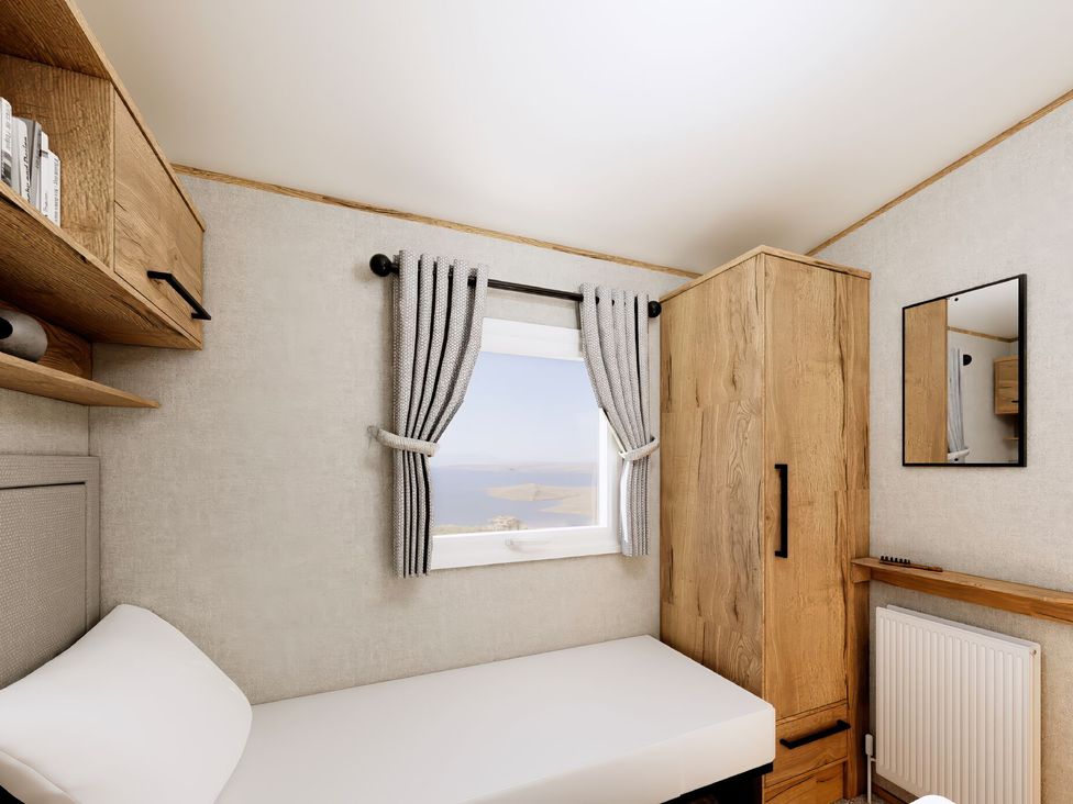 A bedroom with a bed, window, and cupboard at Willow Spa in Carlton Miniott near Thirsk