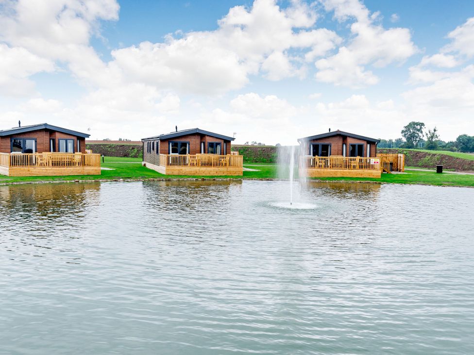 Three cabins by a lake with a fountain at Spindle Spa Carlton Miniott near Thirsk