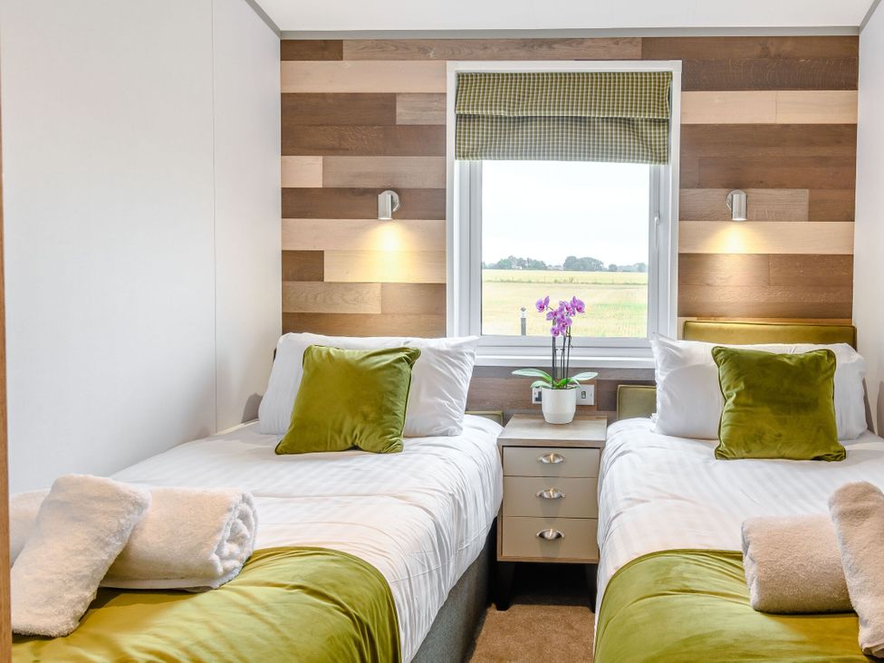 A bedroom with two beds and a window at Spindle Spa, Carlton Miniott near Thirsk