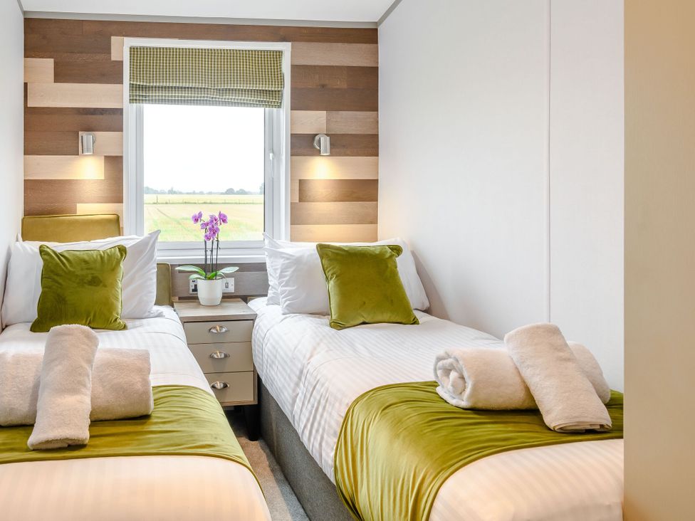A bedroom with twin beds and a window at Spindle Spa Carlton Miniott near Thirsk