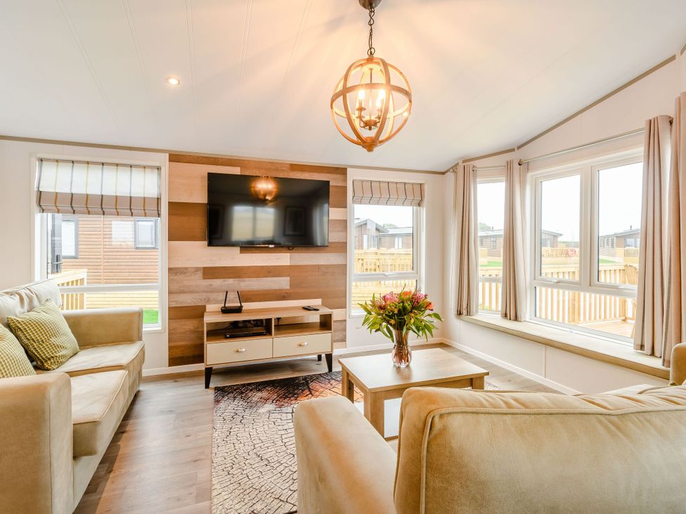 A living room with a television and sofa at Spindle Spa (Pet) Carlton Miniott near Thirsk