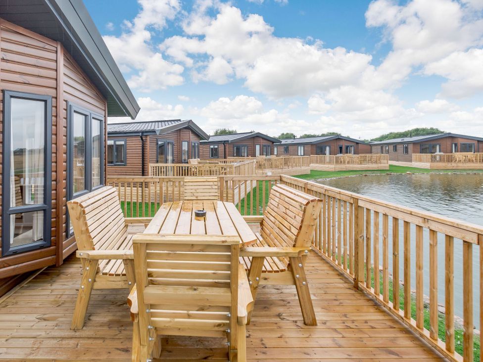 An outdoor seating area with table and benches at Spindle Spa (Pet) Carlton Miniott near Thirsk