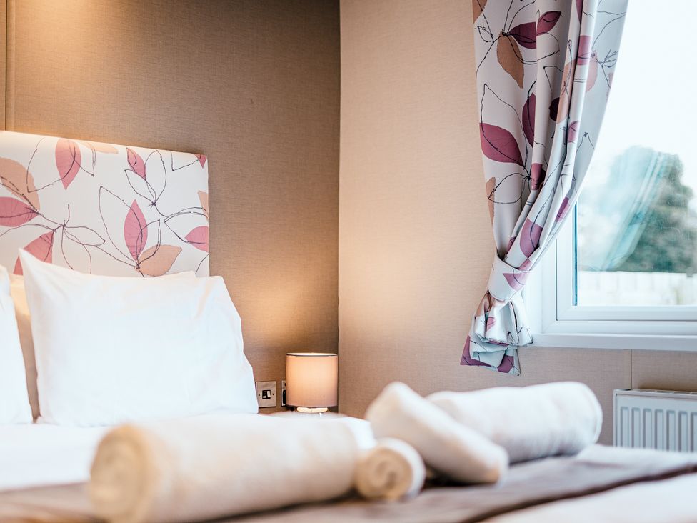 A bedroom with a bed and lamp at Oak Spa (Pet) Carlton Miniott near Thirsk