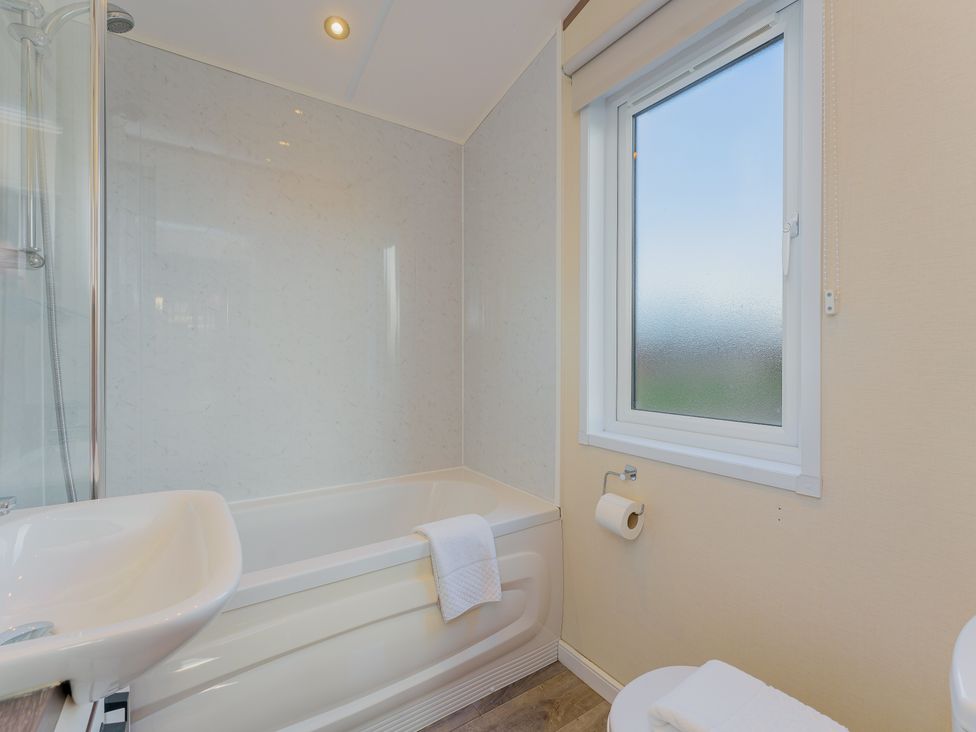 A bathroom with a bathtub, shower, sink, and toilet at Oak Waterside Spa (Pet) Carlton Miniott near Thirsk
