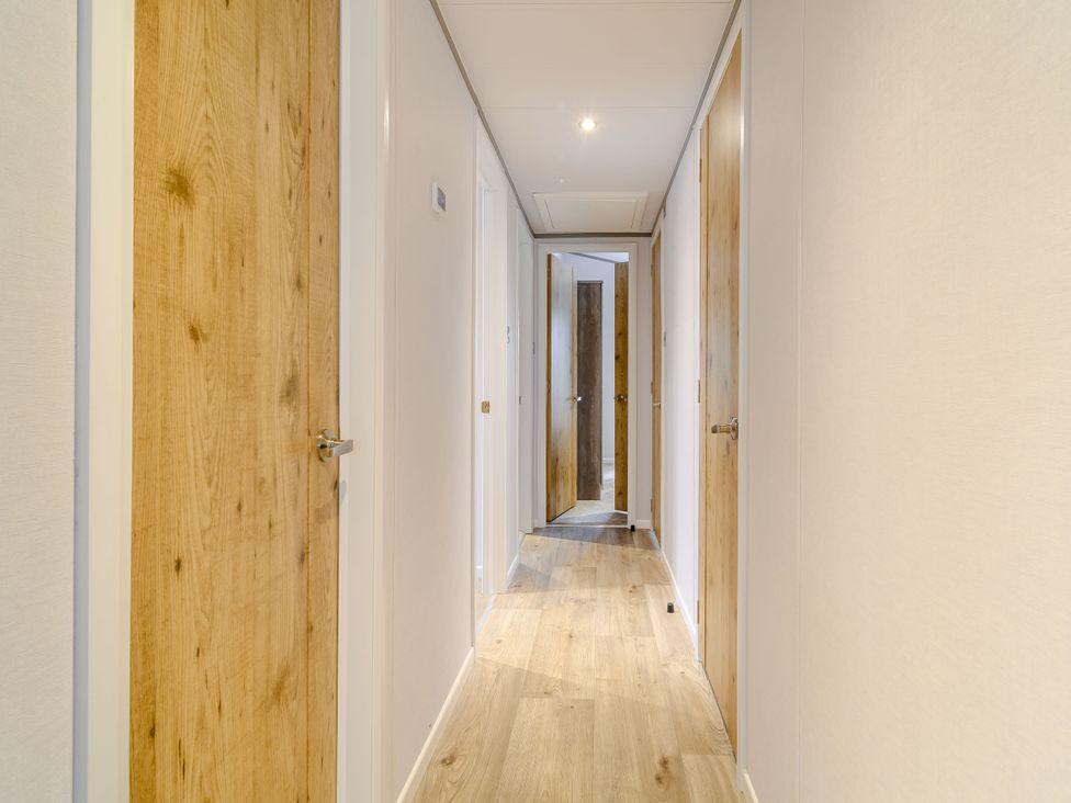 A hallway with doors and flooring at Oak Waterside Spa (Pet) Carlton Miniott near Thirsk