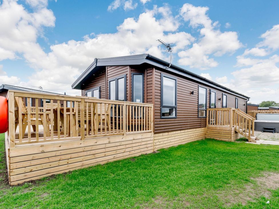A cabin with decking and steps at Beech Waterside Spa Carlton Miniott near Thirsk