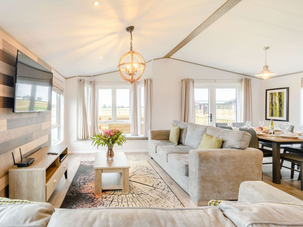 A living room with a sofa and television at Beech Waterside Spa Carlton Miniott near Thirsk