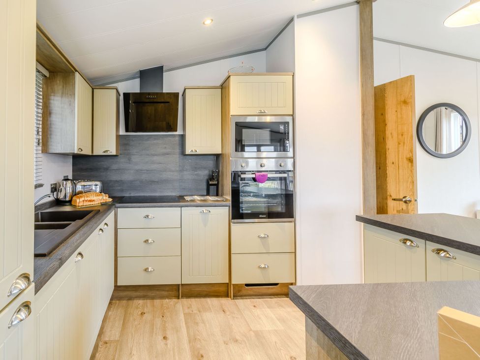 A kitchen with cabinets, oven, sink, and appliances at Beech Waterside Spa, Carlton Miniott near Thirsk