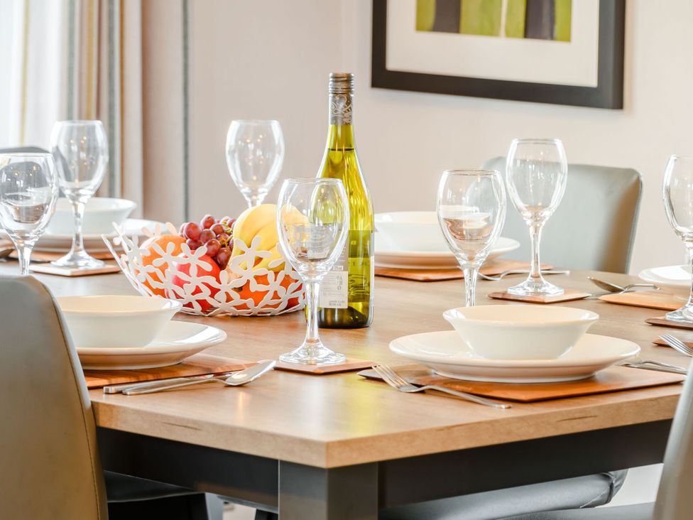 A dining table set with a wine bottle and fruit bowl at Beech Waterside Spa Carlton Miniott near Thirsk
