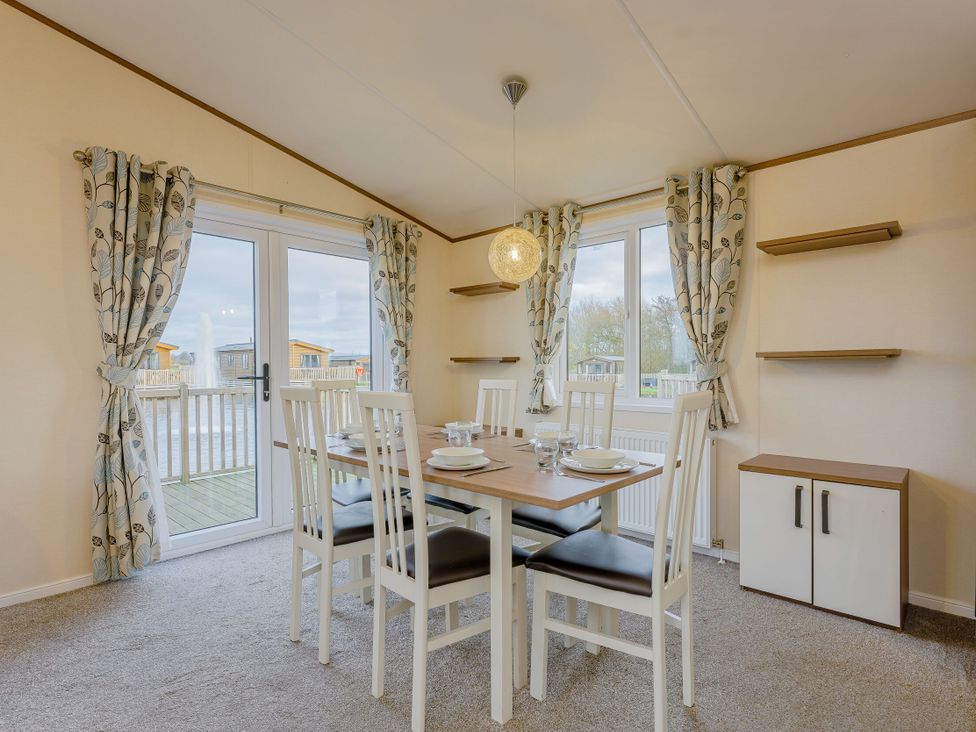 A dining room with a table and chairs at Larch Waterside Spa (Pet) Carlton Miniott near Thirsk