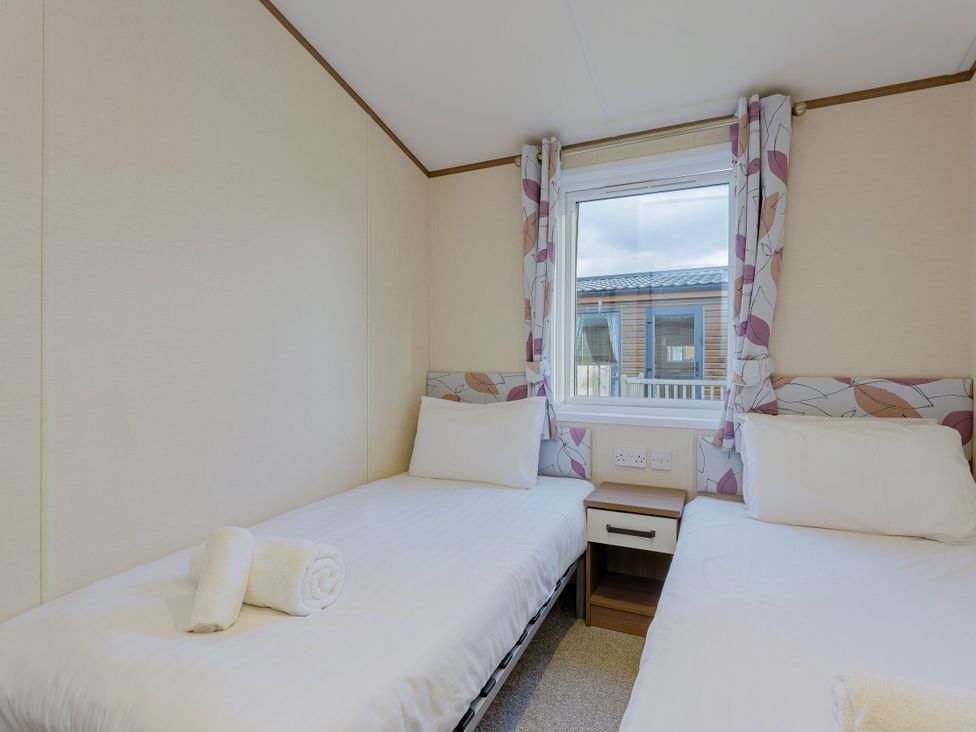 A bedroom with two single beds at Larch Waterside Spa (Pet) Carlton Miniott near Thirsk