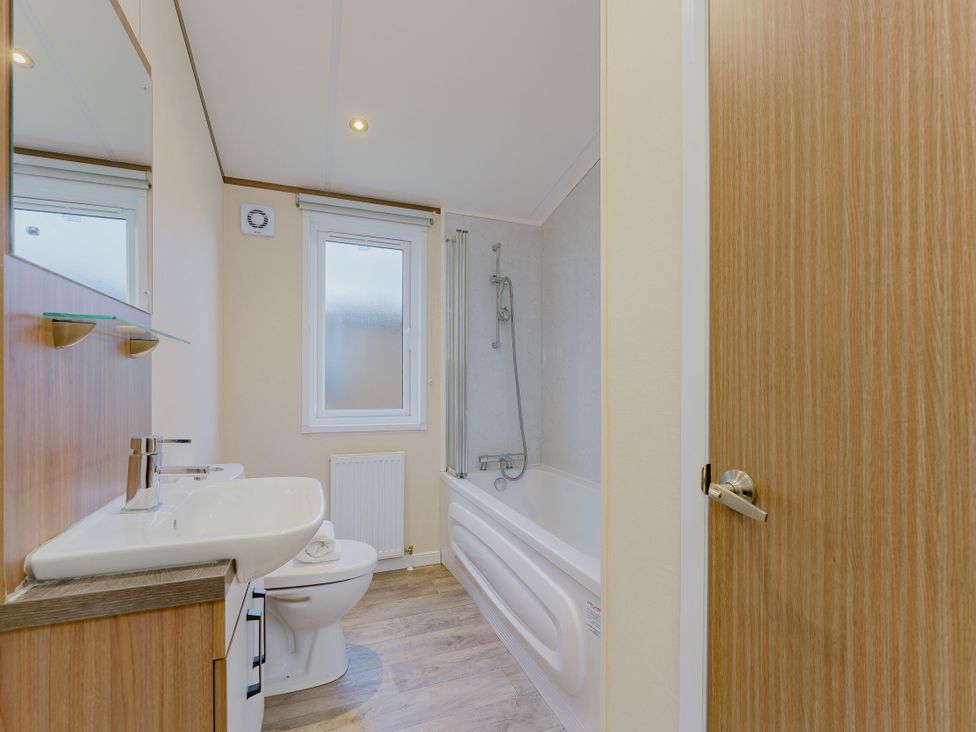 A bathroom with a sink, toilet, and bathtub at Larch Waterside Spa (Pet) Carlton Miniott near Thirsk