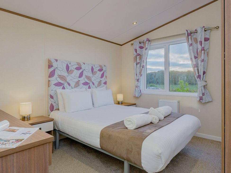 A bedroom with a double bed and a window at Larch Waterside Spa (Pet) Carlton Miniott near Thirsk