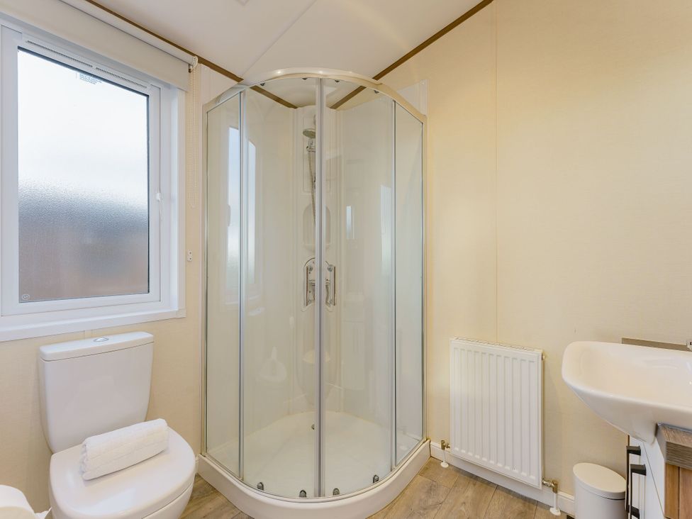 A bathroom with a shower, toilet, and sink at Larch Waterside Spa (Pet) Carlton Miniott near Thirsk