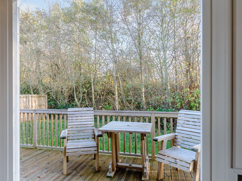 An outdoor area with wooden chairs and table at Cherry Tree in Carlton Miniott near Thirsk