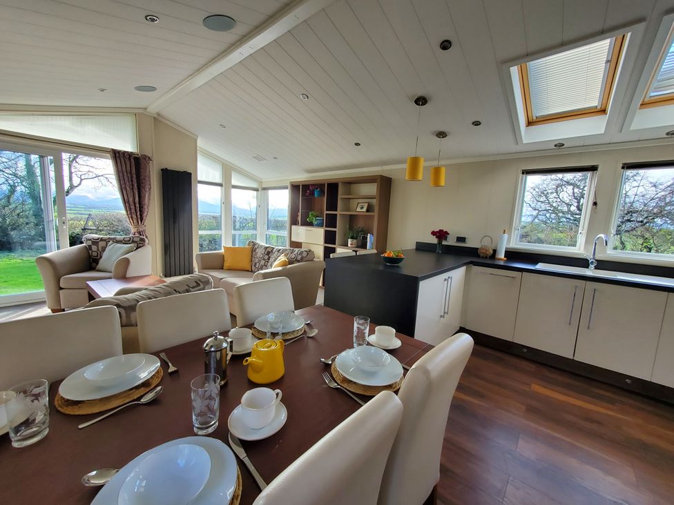 A kitchen with a dining table and seating area at Plas Marchog Lodge, Pentraeth