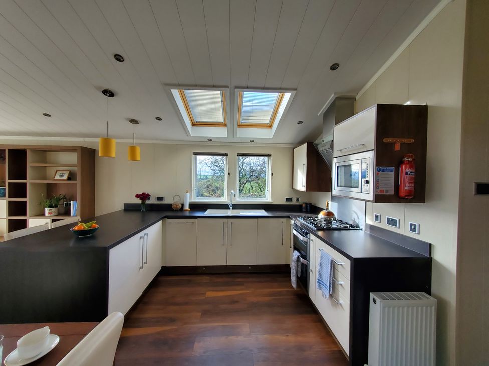 A kitchen with sink and stove at Plas Marchog Lodge in Pentraeth