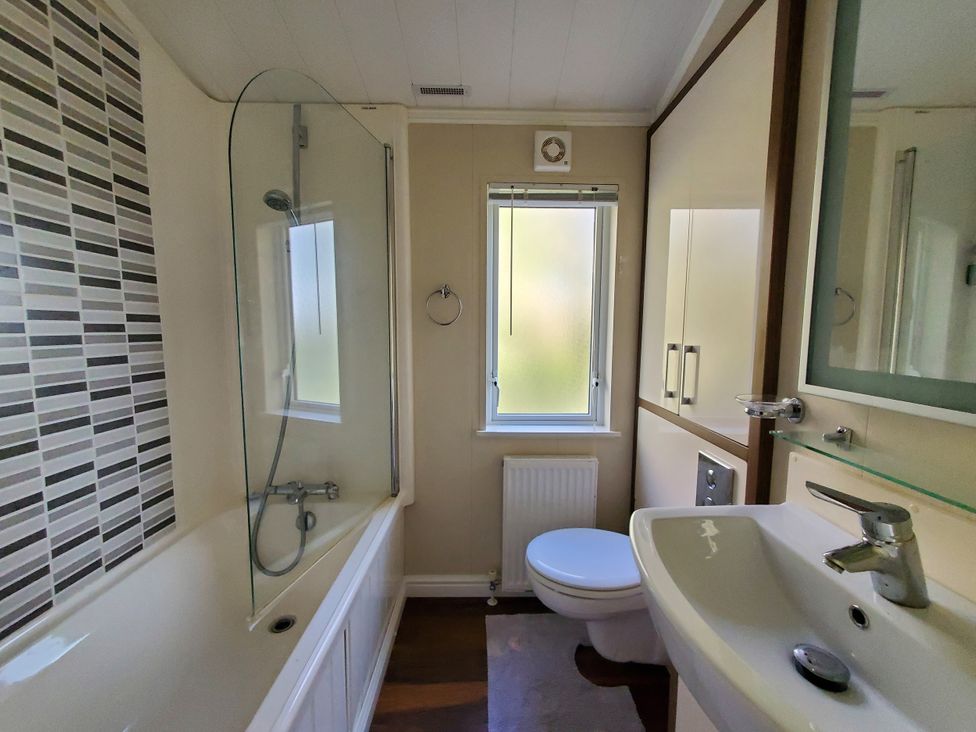 A bathroom with bathtub and shower at Plas Marchog Lodge in Pentraeth