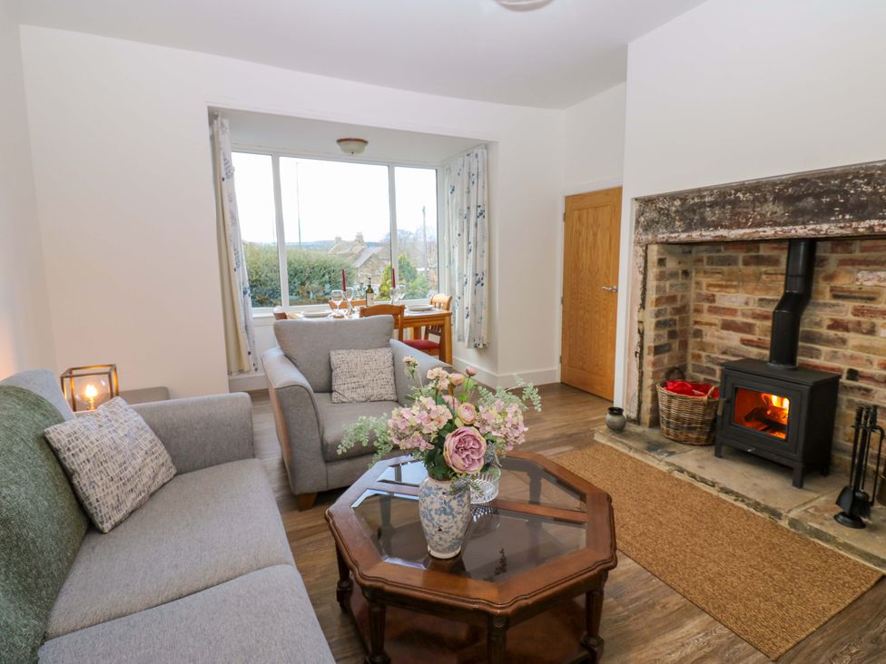 A living room with a fireplace and sofa at Mains Cottage in Consett