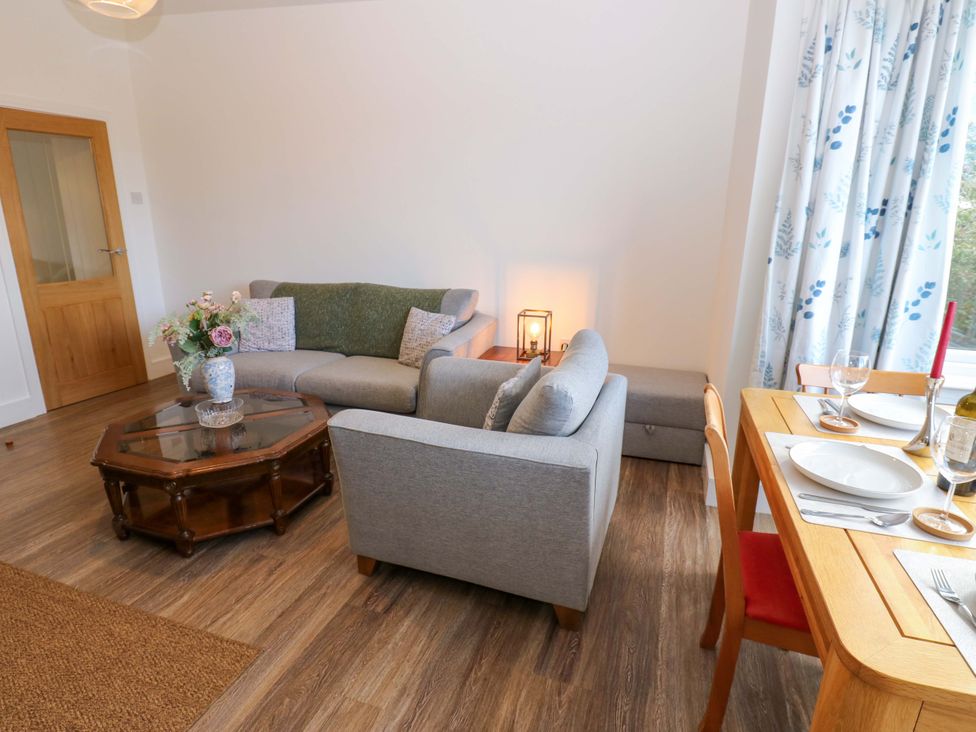 A living room with a sofa and dining table at Mains Cottage in Consett