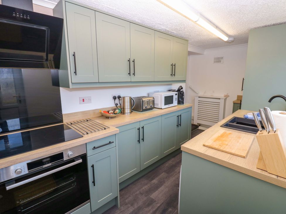A kitchen with cabinets, countertop, and kitchen appliances at Mains Cottage in Consett
