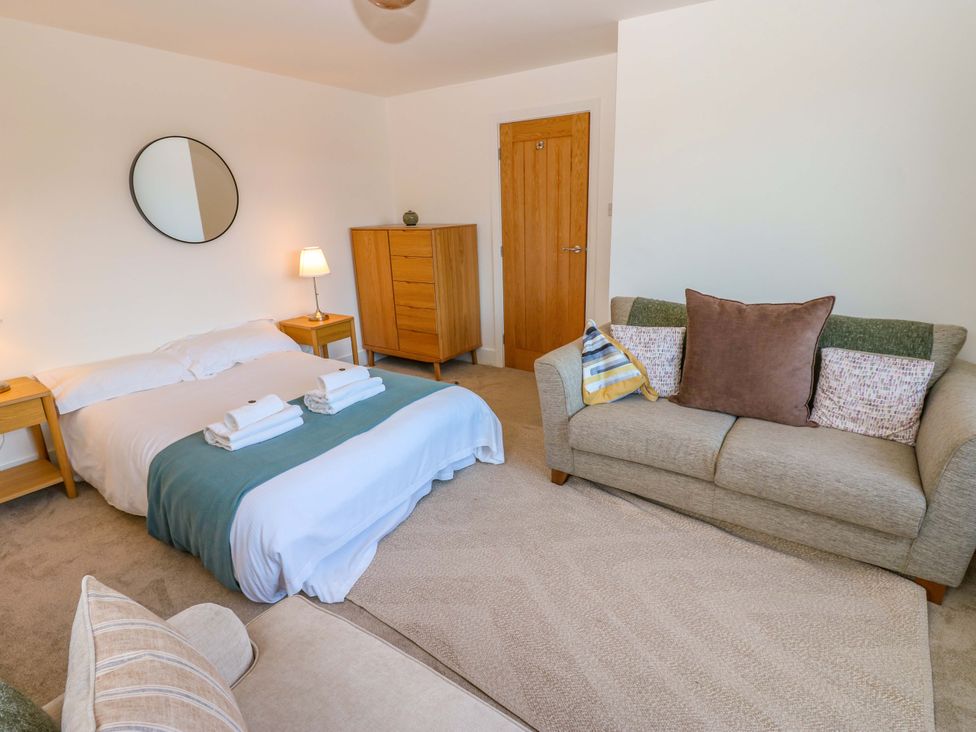 A bedroom with a bed and sofa at Mains Cottage in Consett