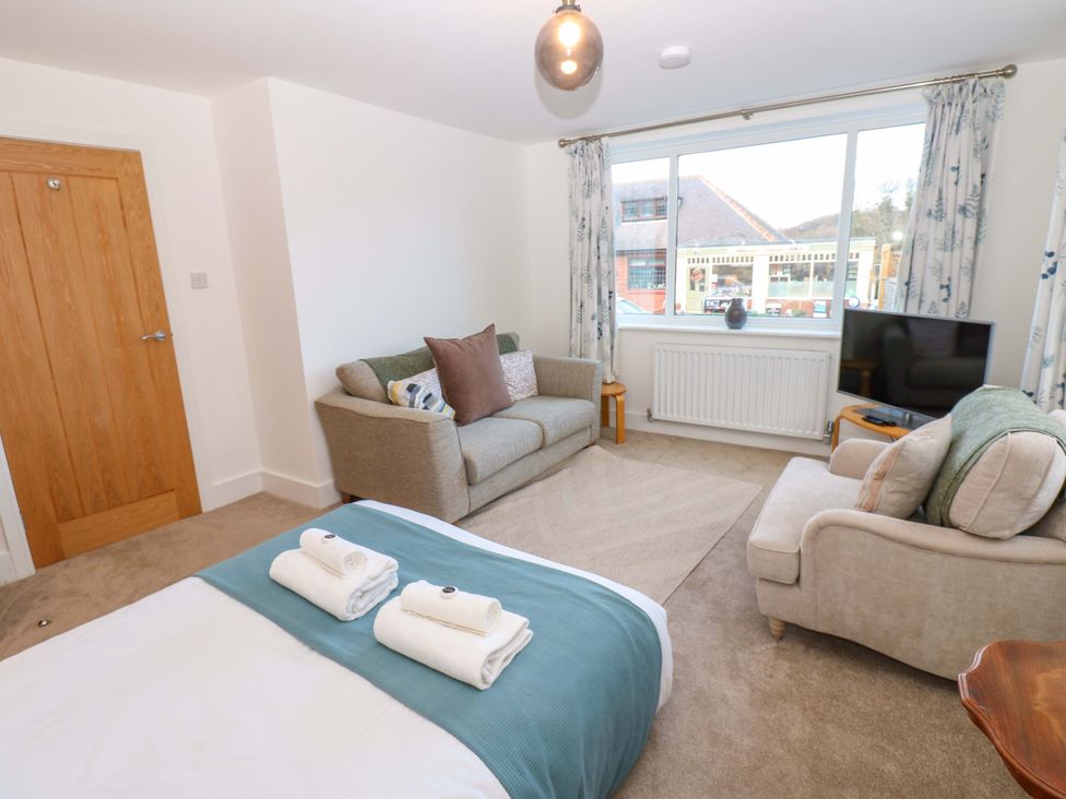 A bedroom with a bed and sofa at Mains Cottage in Consett