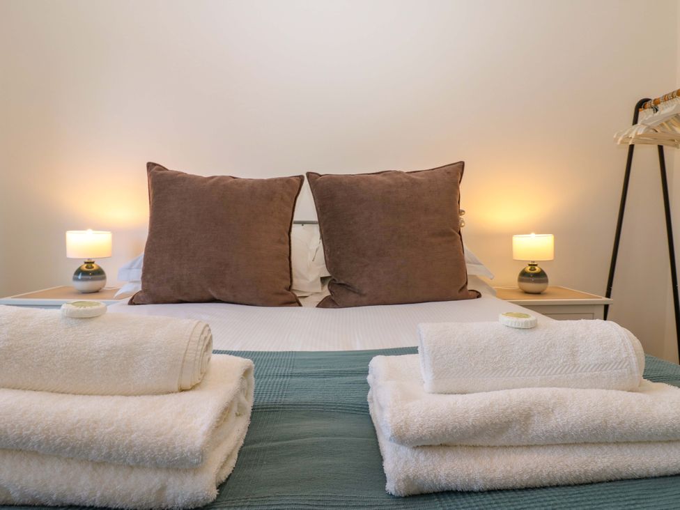 A bedroom with a bed and towels arranged at Mains Cottage in Consett
