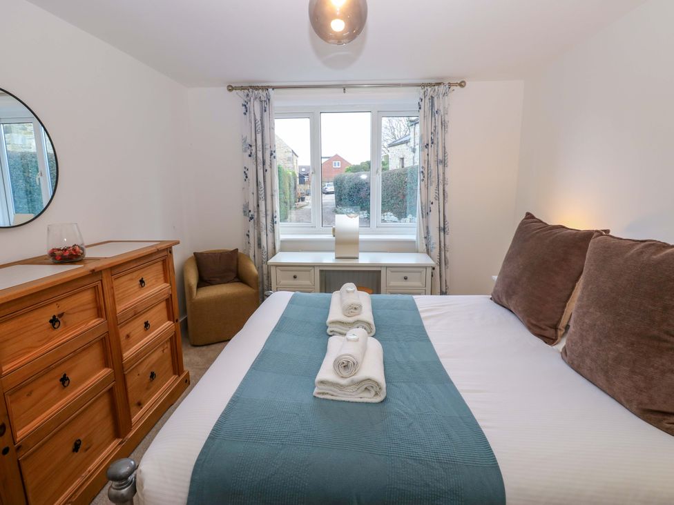 A bedroom with a bed and a dresser at Mains Cottage in Consett