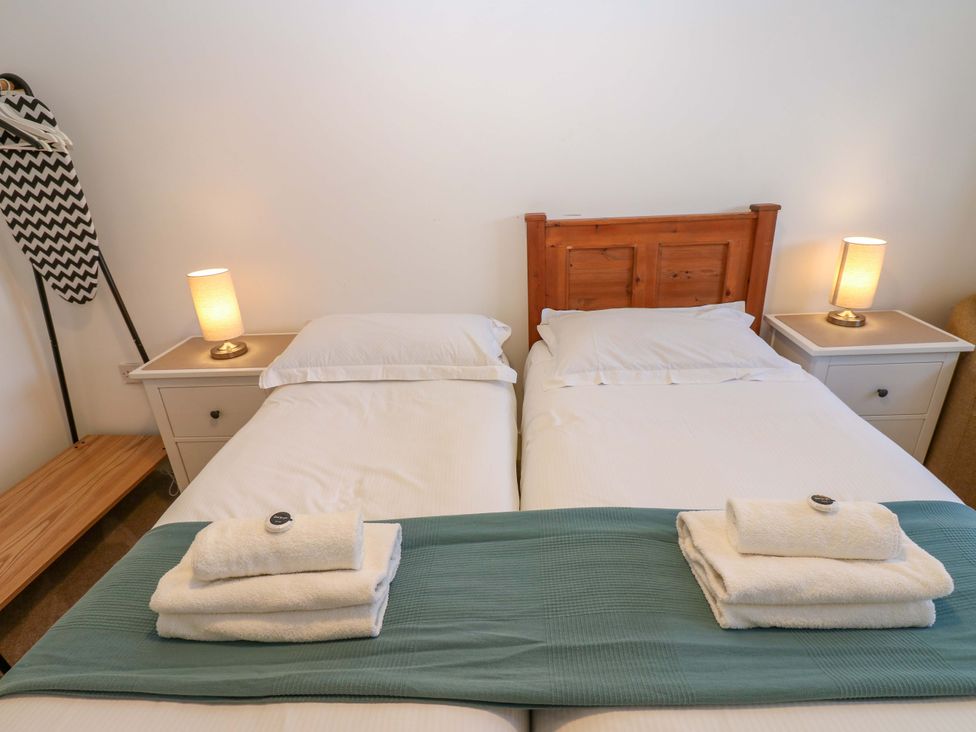 A bedroom with two beds and bedside lamps at Mains Cottage in Consett