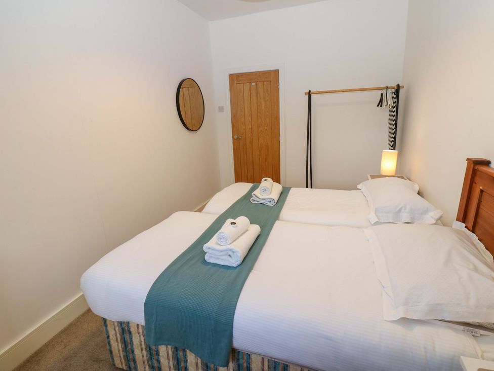 A bedroom with two beds and towels at Mains Cottage in Consett