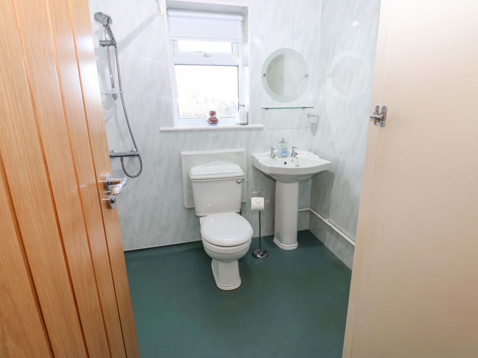 A bathroom with a toilet, sink, and shower at Mains Cottage in Consett
