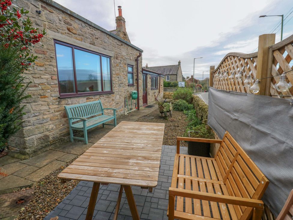 An outdoor area with a table and bench at Mains Cottage in Consett