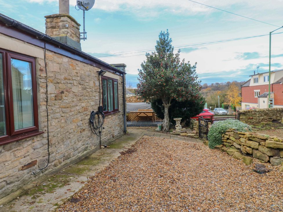 A garden with gravel path and a tree at Mains Cottage in Consett